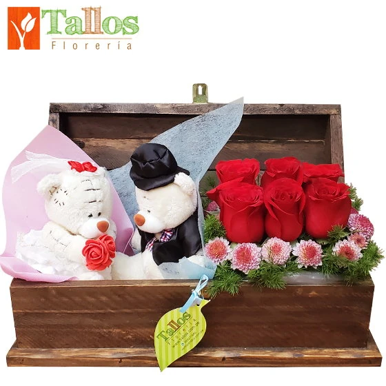 Arreglo floral con rosas rojas y peluches de novios en baúl de madera ideal para aniversario o regalo de amor romántico con entrega a domicilio en Lima