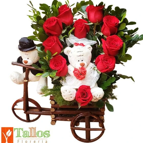 Arreglo floral con rosas rojas y peluches de novios en carreta rústica ideal para aniversario o regalo de amor romántico con entrega a domicilio en Lima